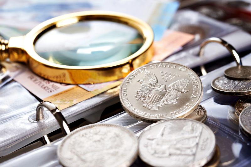Old blue seal silver certificates and coins under a magnifier at a Dallas appraisal